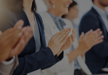 Image depicts a number of professionals clapping their hands