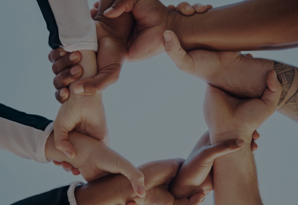 Image depicts a several hands held together, representing unity