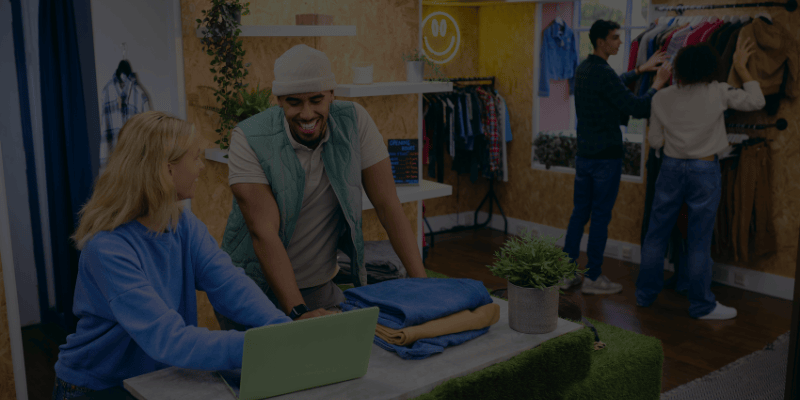 two employees discussing at counter while customers browse products in the backdrop