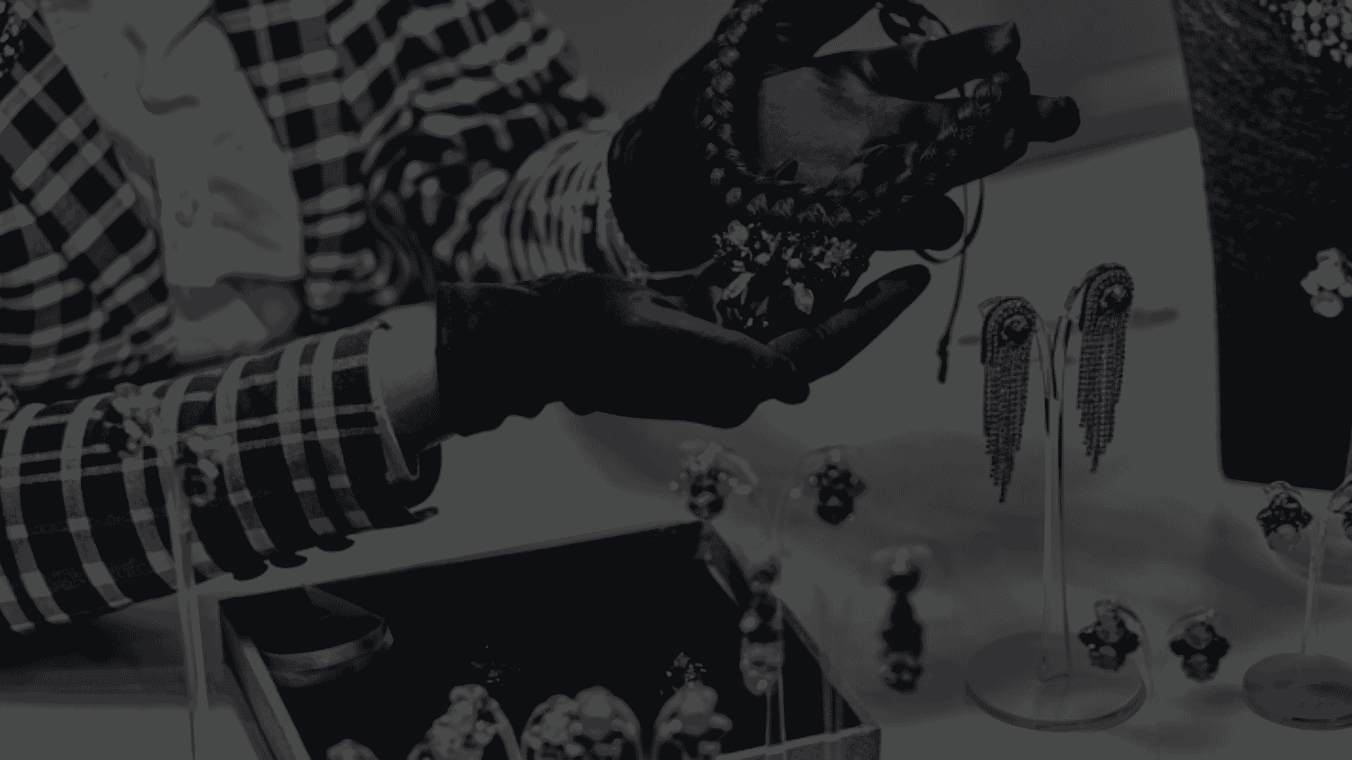 gloved hands holding a piece of jewelry