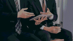 Two officials sitting together and discussing questions to ask to an IBM Sterling OMS Implementation Partner.