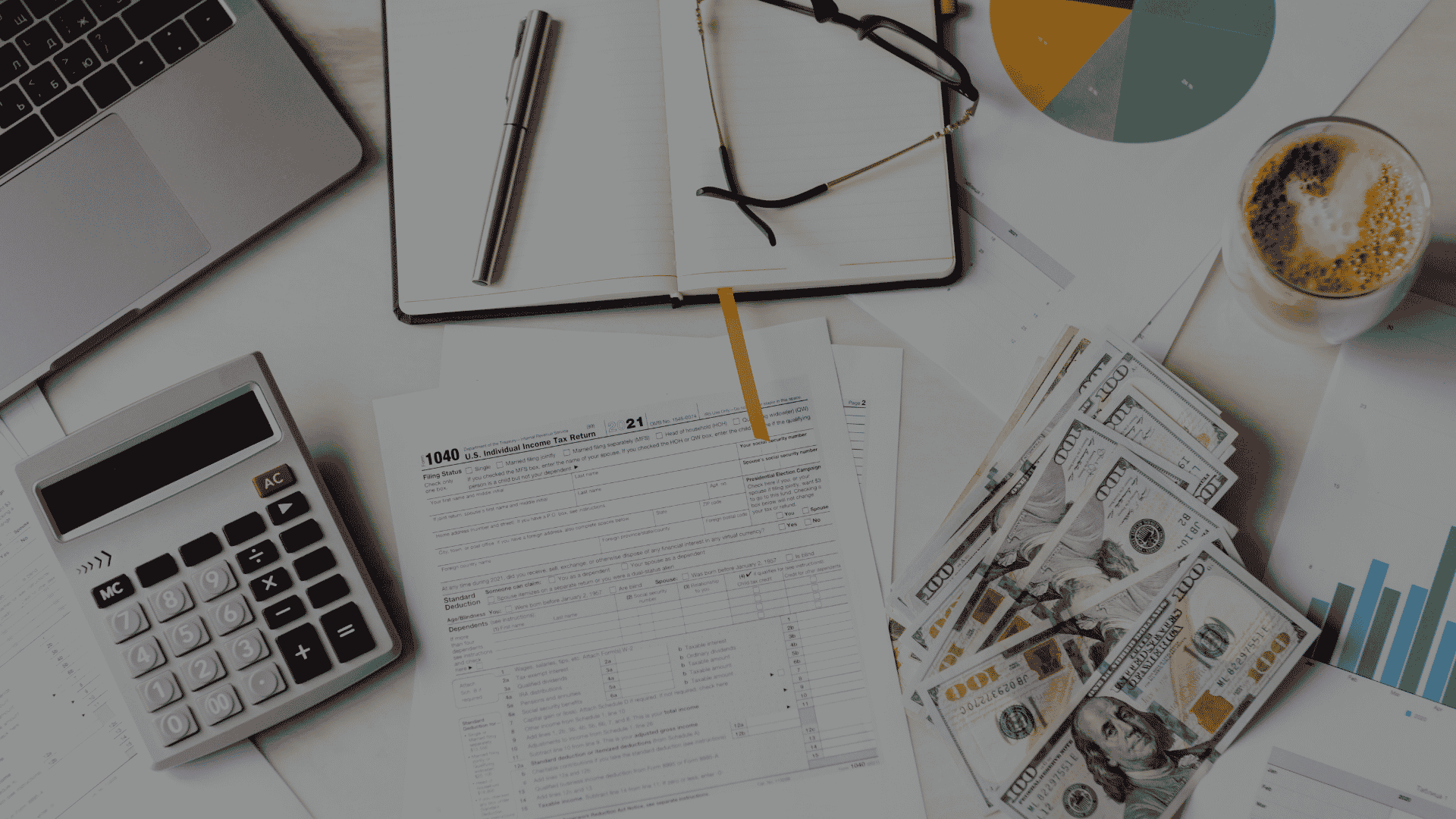 Flat-lay of a form surrounded by a calculator, laptop, glasses, notebook, coffee, cash, and financial charts.