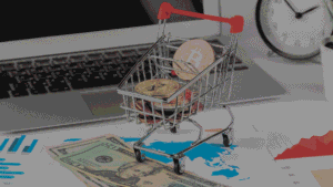 Miniature shopping cart filled with cryptocurrency coins sits on financial charts
