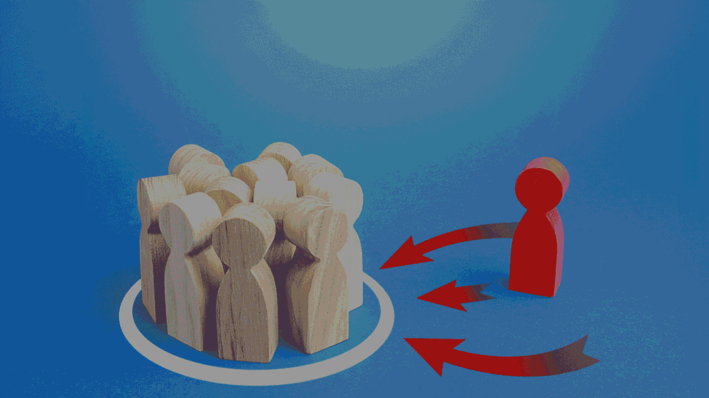 A red wooden figure stands apart from a group of natural wood figures enclosed in a circle, with red arrows pointing toward the group